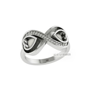 May include: A silver infinity ring with two heart-shaped cutouts and a row of small clear stones. The ring is engraved with the text "925" and "A1SILVERHUB".