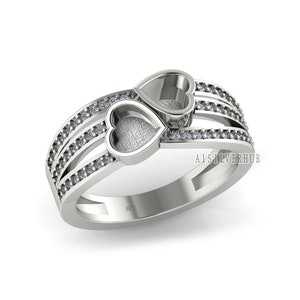 May include: A silver ring featuring two interlocking heart-shaped cutouts, each adorned with a row of small clear stones. The ring is marked "925" on the inside band.