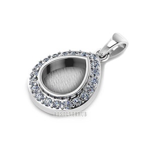 May include: Silver pendant with a teardrop-shaped bezel set with clear stones. The pendant has a bail for attaching to a chain.