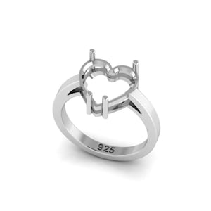 May include: A silver ring featuring a heart-shaped setting. The ring has a polished finish and the number "925" is stamped on the band. The heart setting has four prongs to hold a gemstone.