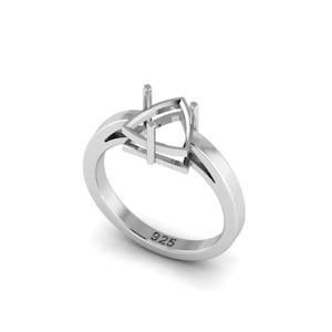 Puede incluir: Un anillo plateado con un engaste triangular. La banda del anillo es lisa y se estrecha hacia la parte posterior, con una pequeña inscripción "925" en el interior. El engaste tiene cuatro garras para sujetar una piedra preciosa.