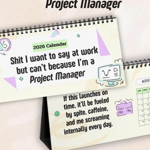 May include: A desk calendar for 2026 with a spiral binding. The calendar has humorous text and illustrations, including the phrases "Shit I want to say at work" and "If this launches on time." The calendar is designed for project managers.