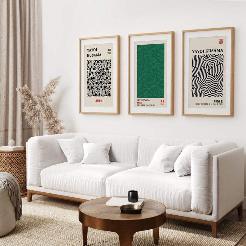Puede incluir: Tres impresiones de arte enmarcadas con dise&ntilde;os abstractos en blanco y negro. Las impresiones est&aacute;n colgadas en una pared blanca sobre un sof&aacute; blanco. Las impresiones son de Yayoi Kusama.