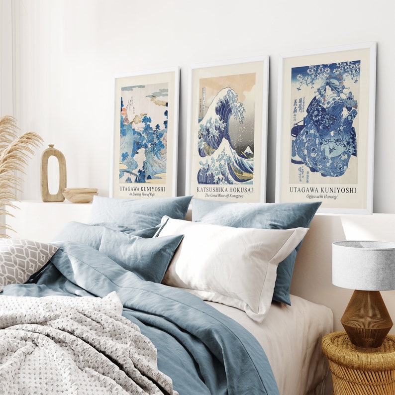 May include: Three framed Japanese woodblock prints, featuring blue and white designs. The prints are titled "The Great Wave off Kanagawa" by Katsushika Hokusai, "An Evening View of Fuji" by Utagawa Kuniyoshi, and "Ogiya Ichi Hanamori" by Utagawa Kuniyoshi.