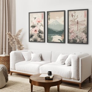 May include: Three framed prints with Japanese-inspired artwork. The left print features pink flowers and a dragonfly. The center print shows a mountain range and a lake. The right print features a dragonfly and pink flowers.