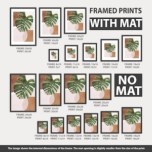 May include: A chart showing different frame and print sizes for a framed print with a mat. The print features a green monstera leaf with a pink and brown background. The chart shows the frame size in inches and the print size in inches. The chart also includes the text "FRAMED PRINTS WITH MAT" and "NO MAT".