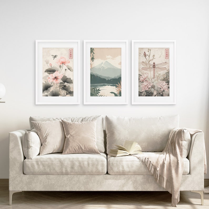 May include: Three framed prints with a Japanese theme. The left print features pink flowers and green leaves. The center print shows a mountain range with a lake in the foreground. The right print features a dragonfly and pink flowers.