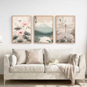 May include: Three framed prints with a Japanese theme. The left print features pink flowers and a dragonfly. The center print shows a mountain range with a lake in the foreground. The right print features pink flowers and a dragonfly.