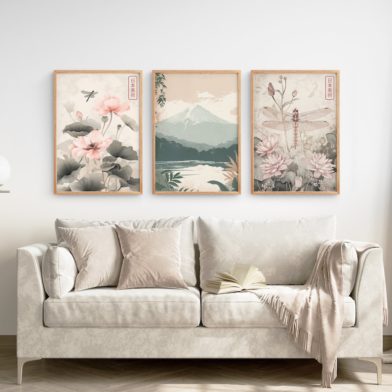 May include: Three framed prints with a Japanese theme. The left print features pink flowers and a dragonfly. The center print shows a mountain range with a lake in the foreground. The right print features pink flowers and a dragonfly.