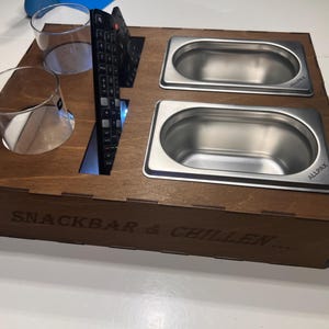 Könnte beinhalten: Ein Snack- und Chill-Tablett aus Holz mit zwei Schalen aus Edelstahl, zwei Gläsern und einem Fernbedienungs-Halter. Das Tablett ist mit dem Text "Snack Bar & Chillen..." graviert und die Schalen sind mit "Allpax" beschriftet.