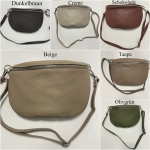 May include: Five different coloured leather fanny packs with a zipper closure. The colours are dark brown, cream, brown, beige, and olive green.