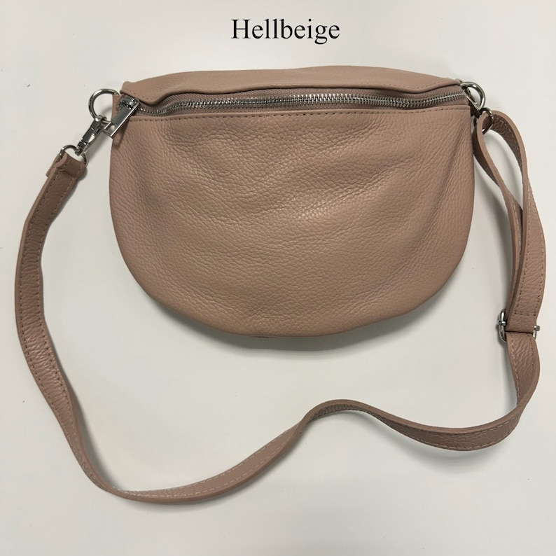 May include: A light pink leather fanny pack with a silver zipper and adjustable strap.