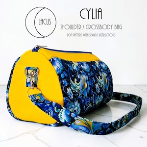 May include: A cylindrical shoulder/crossbody bag with yellow end panels and a blue floral patterned body. The bag has a blue strap and a zipper closure. Text on the image reads "CYLIA SHOULDER / CROSSBODY BAG PDF PATTERN WITH SEWING INSTRUCTIONS".
