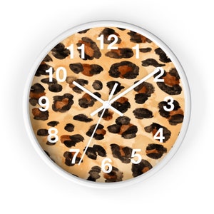 May include: A white round clock with black hands and white numbers on a leopard print background.