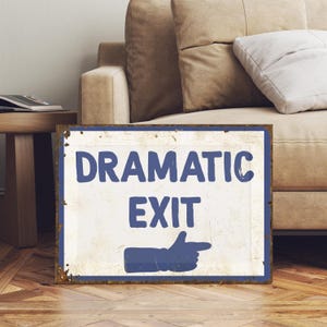 May include: A white metal sign with blue text and a blue pointing hand. The sign reads "Dramatic Exit".