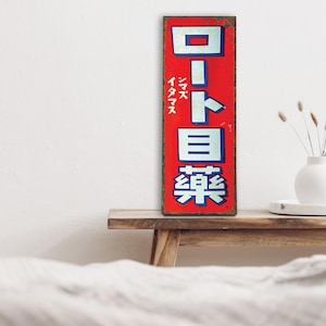 以下が含まれることがあります： 赤い金属製のレトロな看板に、日本語で「ロート目薬」と書いてあります。これは「ロート目薬」と読みます。