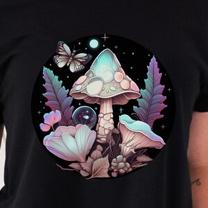 May include: Black t-shirt with a circular graphic of a glowing mushroom with a butterfly and flowers in a dark forest setting.