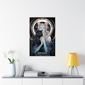 Puede incluir: Una ilustraci&oacute;n de carta de tarot de La Suma Sacerdotisa, una mujer con el pelo largo y rubio y un gato negro en sus brazos. Lleva una t&uacute;nica azul y blanca y una corona. El fondo es negro con estrellas y una luna.