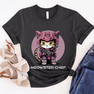 May include: A black t-shirt with a pink circle graphic of a cat wearing a pink and gray space suit holding a gun. The text "MEOWSTER CHIEF" is printed below the graphic.