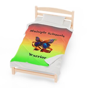 May include: A green, yellow, orange, and red gradient throw blanket with a butterfly and the text "Multiple Sclerosis Warrior".