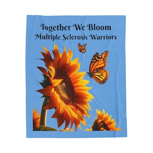 May include: A blue background with the text "Together We Bloom Multiple Sclerosis Warriors" in black. A large yellow sunflower with a brown center is in the foreground. Two orange and black monarch butterflies are flying near the sunflower.