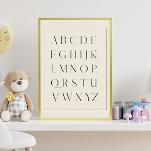 May include: A gold framed print with a white background and black text. The text reads "ABCDE FGHIJK LMNO PQRSTU VWXYZ".