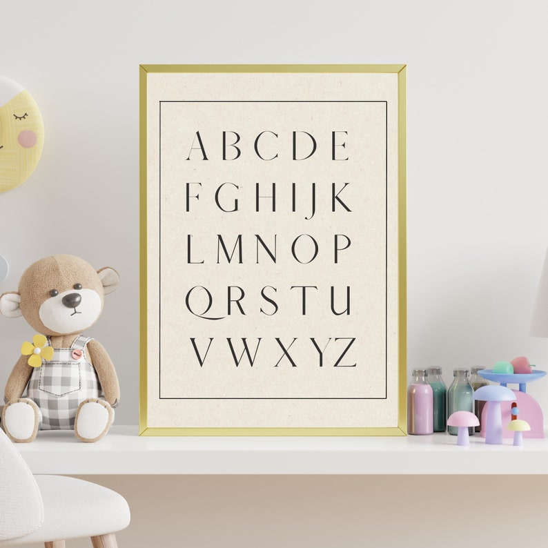 May include: A gold framed print with a white background and black text. The text reads "ABCDE FGHIJK LMNO PQRSTU VWXYZ".