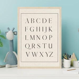 May include: A framed print with a white background and black text. The text is the alphabet in uppercase letters, arranged in rows. The letters are in a simple, modern font.