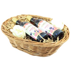 May include: A wicker basket filled with shredded paper, two bottles of Echo Falls Raspberry & Blackberry wine, and white silk flowers.