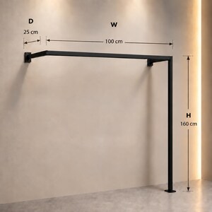May include: A black metal wall-mounted garment rack with a rectangular frame. The structure features a depth of 25 cm, a width of 100 cm, and a height of 160 cm, as indicated by the labeled dimensions D, W, and H printed on the image.