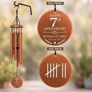 May include: A copper-colored wind chime featuring a circular sail engraved with the text Happy 7th Anniversary, Michael and Emily, and the date July 30, 2018. The reverse side of the sail displays a tally mark graphic representing the number seven.