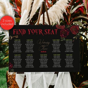 May include: Black chalkboard sign with red floral accents and gold lettering. The sign says "Find Your Seat" and lists table numbers with guest names for a wedding reception on Wednesday, September 28th, 2024.