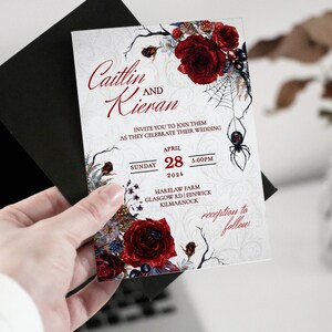 Op de afbeelding: Huwelijksuitnodiging met een gotische uitstraling. De uitnodiging toont een zwarte spin, rode rozen en de tekst "Caitlin en Kieran" met de datum "28 april 2024" en de tijd "17:00 uur".