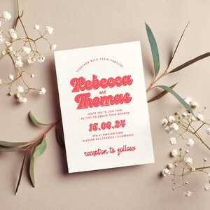 May include: A white wedding invitation with red text. The invitation reads "Together with their families, Rebecca and Thomas invite you to join them as they celebrate their wedding 15.06.24 3pm at Harelaw Farm, Glasgow Rd | Fenwick | Kilmarnock, reception to follow."