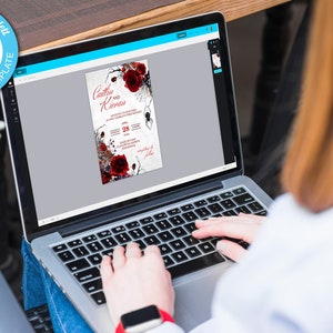 Op de afbeelding: Een persoon gebruikt een laptop om een huwelijksuitnodigingssjabloon te bewerken. De uitnodiging heeft een donkerrood en zwart bloemenontwerp met een spin en de tekst "Caitlin en Kieran".