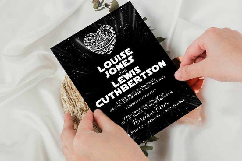 May include: Black and white wedding invitation with a Star Wars theme. The invitation features a Death Star in the shape of a heart with the text "Louise Jones and Lewis Cuthbertson invite you to join them as they celebrate their wedding. Saturday the 4th of May at 3 o'clock in the afternoon. Harelaw Farm. Fenwick. Kilmarnock."