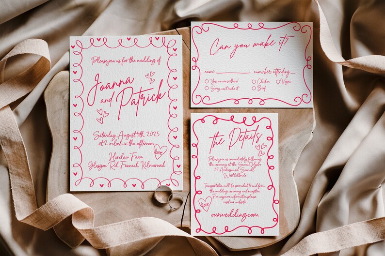 May include: Wedding invitation suite with three cards and a response card. The cards are white with pink text and decorative borders. The invitation reads "Joanna and Patrick" and includes wedding details. Two rings are visible.