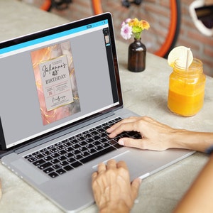 May include: A laptop computer displaying a digital invitation with a marble background and gold accents. The invitation reads "Johannes 40th Birthday".