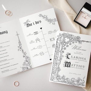 May include: Wedding stationery set featuring a welcome card, ceremony program, and timeline, all with ornate black and white designs. Includes two gold wedding rings and a ring box with a ring inside.