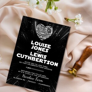 May include: A black and white wedding invitation with a Star Wars theme. The invitation features a Death Star in the shape of a heart with the text "Louise Jones and Lewis Cuthbertson" and the date and location of the wedding.