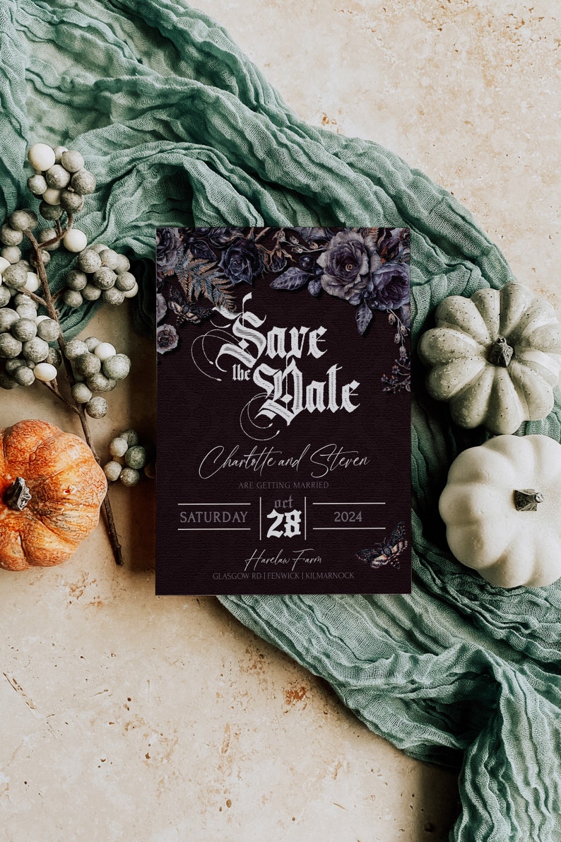 Op de afbeelding: Een bordeauxrode Save the Date kaart met bloemaccenten en de namen Charlotte en Steven. De kaart is omgeven door pompoenen, bessen en een saliegroene stof. De datum is 28 oktober 2024.