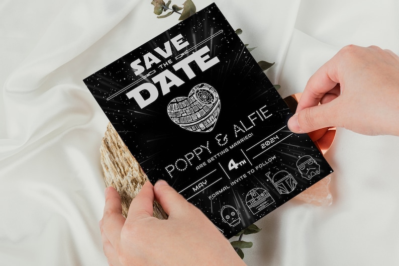 Pu&ograve; includere: Carta di salvataggio della data in bianco e nero con tema Star Wars. La carta presenta una Morte Nera a forma di cuore con il testo "Save the Date" e "Poppy & Alfie si sposano! 4 maggio 2024. Invito formale a seguire."