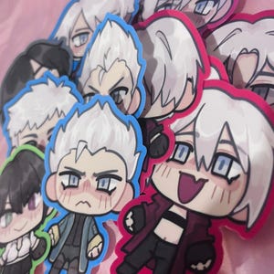 May include: A selection of anime-style stickers depicting characters with white hair and diverse expressions. The stickers have a white border and are set against a pink backdrop. Some characters are wearing dark jackets.