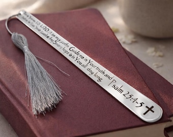 May include: A silver bookmark with a gray tassel rests on a burgundy book. The bookmark has an engraved cross and text from Psalm 25:4-5. The bookmark is approximately 7 inches long.
