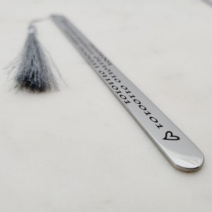May include: Silver bookmark with a gray tassel and the text "10101010 01100110 01100101 01110010 01110100 01101000 01100101 01110011 00100000 01100011 01101111 01110010 01100101 01110011 01110100 01101000 01100101 01110011" and a heart at the end.