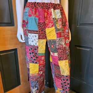May include: Patchwork pants with a red, yellow, green, and blue color scheme. The pants are made of different fabrics and have a unique, handmade look.