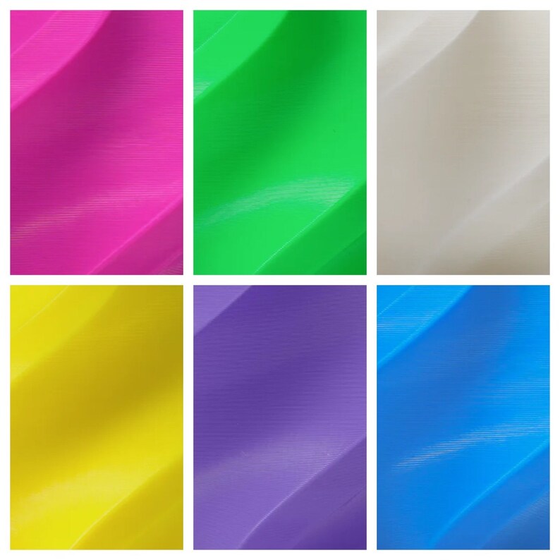 Op de afbeelding: Zes vierkante tegels met een golvend, getextureerd oppervlak. De tegels zijn in zes verschillende kleuren: roze, groen, wit, geel, paars en blauw.