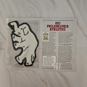 May include: A white and black illustration of an elephant with the text "1927 Philadelphia Athletics" and a description of the team's history and the "The 'A's' Picked to Win the Pennant" in 1927.