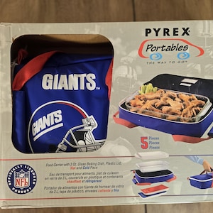 May include: Pyrex food carrier featuring a blue and red Giants logo. The carrier includes a glass baking dish, plastic lid, and hot and cold packs. The box also shows a container of food.