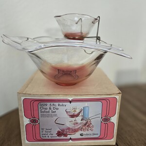 May include: A vintage 5-piece ruby chip and dip salad set. The set includes a large bowl with a built-in spoon rest, a smaller dip bowl, a metal clip, and a fork and spoon. The set is in its original box.